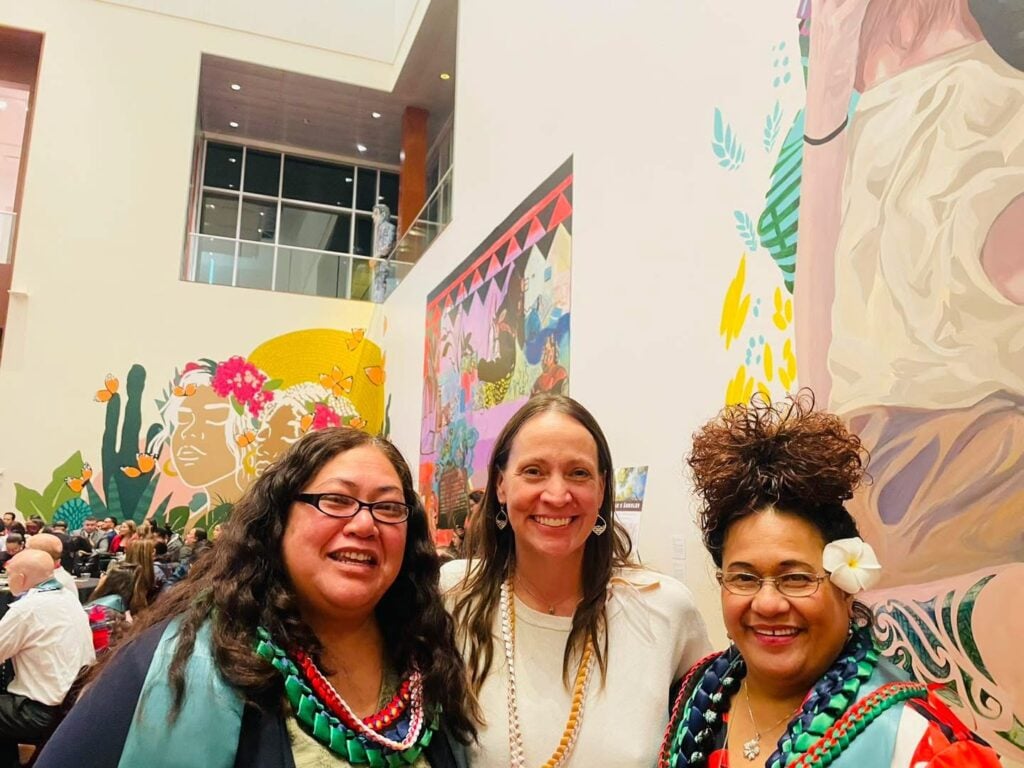 Three people smiling at an event
